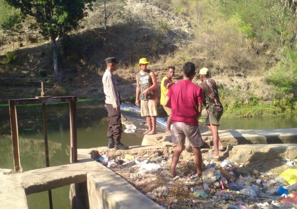 Wujud Polri Peduli, Bhabinkamtibmas Desa Nipa Gotong Royong Bersihkan Saluran Irigasi Bersama Warga